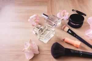 perfumes y cosméticos de maquillaje sobre fondo de madera foto