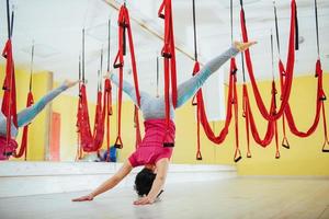 young woman making antigravity yoga exercises photo