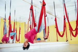 young woman making antigravity yoga exercises photo