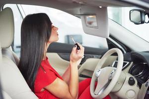 woman in car indoor keeps wheel turning around smiling looking at passengers in back seat idea taxi driver against sunset rays Light shine sky Concept of exam Vehicle - second home the girl photo