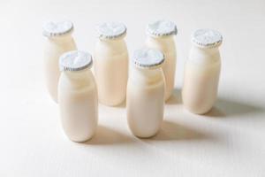 Small bottles with probiotics and prebiotics dairy drink on white background. Production with biologically active additives. Fermentation and diet healthy food. Bio yogurt with useful microorganisms. photo