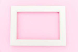 Simply design with empty pink frame isolated on pink pastel colorful background. Top view, flat lay, copy space, mock up. Minimal concept. photo