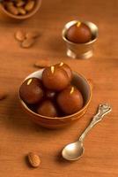 Gulab Jamun in bowl and copper antique bowl with spoon. Indian Dessert or Sweet Dish. photo