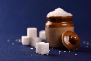 Sugar. white granulated sugar and refined sugar on a blue background photo