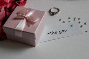 Note miss you with gift box, ring and handkerchief on white background photo