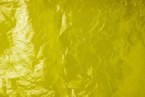 la textura de la bolsa de plástico sobre un fondo amarillo. bolsa transparente arrugada, plástico foto