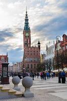 gdansk, polonia, 15 de abril de 2018, la gente camina por dluga long market street dlugi targ square en el antiguo centro histórico cerca del ayuntamiento con la torre del reloj, hermosos edificios típicos de casas coloridas