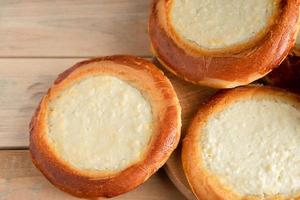 Homemade buns with cottage cheese on wooden background. photo