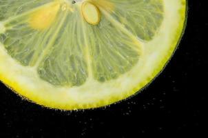 limón en detalle de burbujas de agua foto