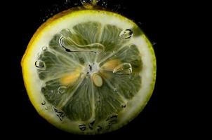 fresh yellow lemon in water with bubbles