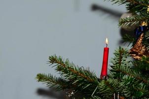 burning candle on christmas tree photo