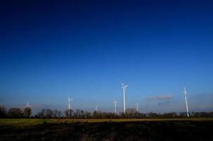 many wind turbines and blue sky photo