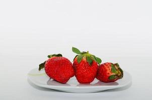 three strawberries on plate photo