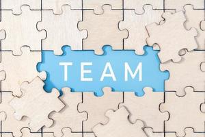 Team word on blue background surrounded by puzzle pieces photo