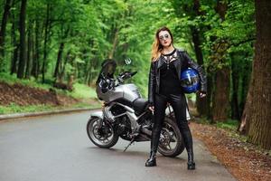 An attractive sexy girl on a sports motorbike posing outside photo