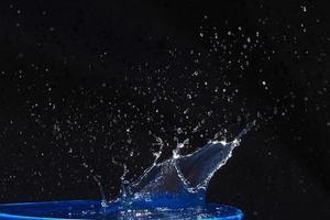 Splash of water crown on blue surface. photo