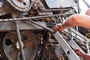 Combine machine service, mechanic repairing motor outdoors photo