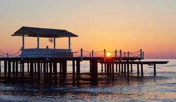 Wooden pier on a fancy orange sunset. photo