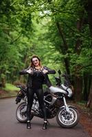 An attractive sexy girl on a sports motorbike posing outside photo