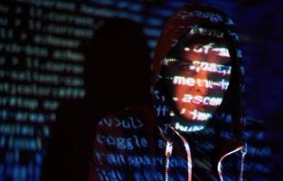 ataque cibernético con un hacker encapuchado irreconocible usando realidad virtual, efecto de falla digital foto