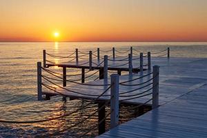 Wooden pier on a fancy orange sunset. photo