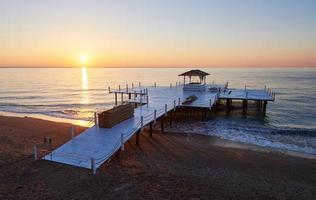 Wooden pier on a fancy orange sunset. photo