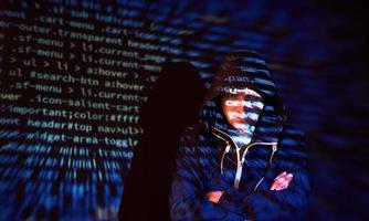 Cyber attack with unrecognizable hooded hacker using virtual reality, digital glitch effect photo