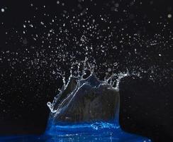 Splash of water crown on blue surface. photo