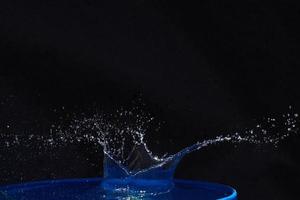 Splash of water crown on blue surface. photo