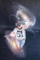 Young beautiful girl gets positive emotions using virtual reality goggles. A woman examines star via Augmented Reality. photo