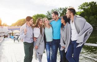 A group of young and successful people on vacation at the pier in the sun photo