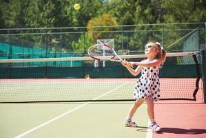 linda chica jugando al tenis y posando para la cámara foto