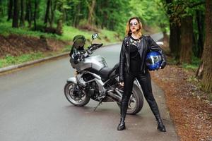 una atractiva chica sexy en una moto deportiva posando afuera foto