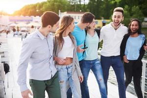 grupo de jóvenes sonrientes y exitosos de vacaciones en el muelle foto