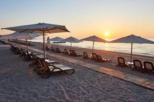 Scenic view of sandy beach on the beach with sun beds and umbrellas open against the sea and mountains. Hotel. Resort. Tekirova-Kemer photo