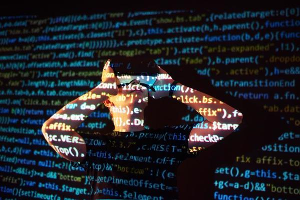 Double exposure of a caucasian man and Virtual reality headset is presumably a gamer or a hacker cracking the code into a secure network or server, with lines of code