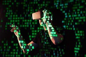 Double exposure of a caucasian man and Virtual reality headset is presumably a gamer or a hacker cracking the code into a secure network or server, with lines of code photo