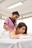 Portrait of young beautiful asian woman enjoys massage in a luxury spa resort photo