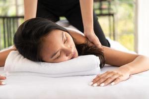 Portrait of young beautiful asian woman enjoys massage in a luxury spa resort photo