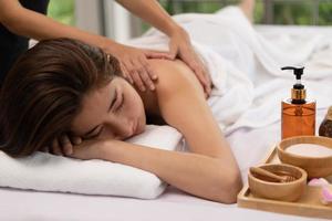 Portrait of young beautiful asian woman enjoys massage in a luxury spa resort photo