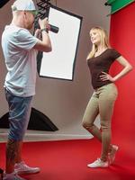 Model posing to photographer in studio on red background. Professional, education, technology concept photo