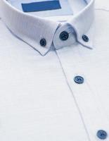 cotton shirt with a focus on the collar and button, closeup photo