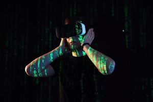Double exposure of a caucasian man and Virtual reality headset is presumably a gamer or a hacker cracking the code into a secure network or server, with lines of code photo