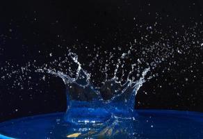 Splash of water crown on blue surface. photo