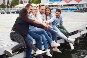 Group of happy young friends on the pier, pleasure in playing creates emotional life photo