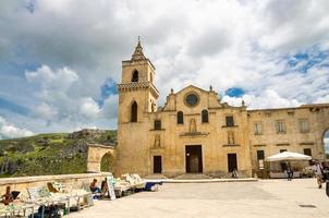 Matera, Italy - May 6, 2018 Church Chiesa San Pietro Caveoso on the square in front of ravine with caves di Murgia Timone in historical centre old ancient town Sassi, UNESCO, Basilicata