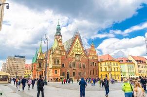 Wroclaw, Poland, May 7, 2019 Old Town Hall building with clock tower spire and crowd of many people photo