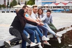 Group of happy young friends on the pier, pleasure in playing creates emotional life photo