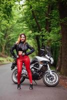 An attractive sexy girl on a sports motorbike posing outside photo