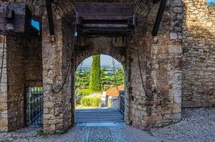 brescia, italia, 11 de septiembre de 2019 muro de piedra con almenas y puerta de puente levadizo del castillo medieval brescia foto